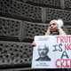 A Julian Assange supporter holds a placard with a message of support for him outside the Old Bailey in London, Monday, Jan. 4, 2021.